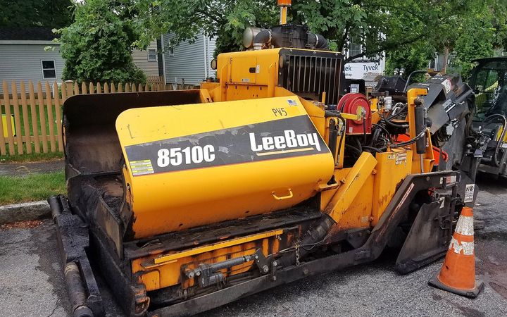 Small asphalt paver parked on a residential street