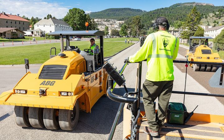 Rubber-tired rollers pressing gravel chips into fresh asphalt
